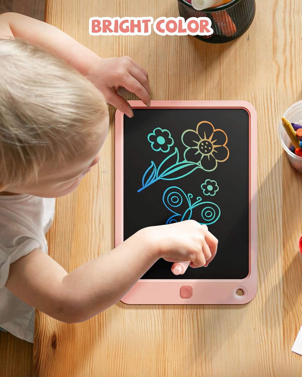 Toddler drawing flowers and butterflies on the Kikapabi LCD Writing Tablet with bright, colorful lines.